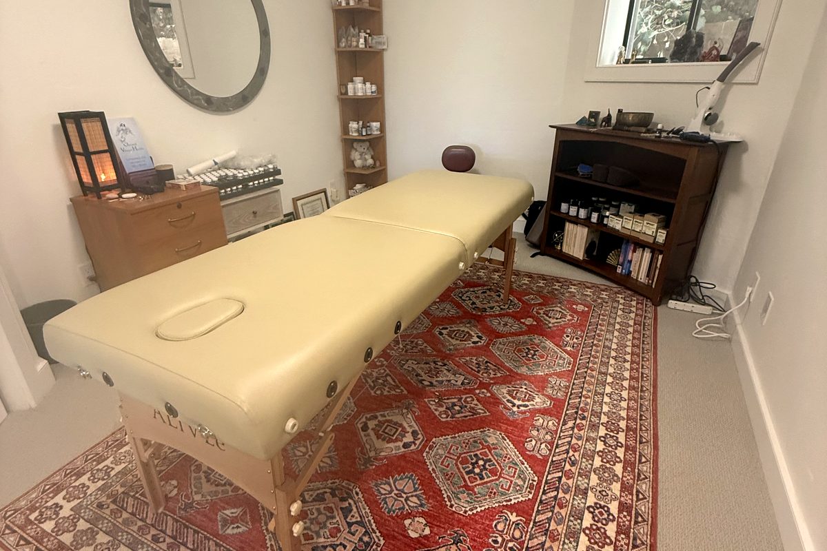 Treatment room at our San Rafael office — massage table on a red oriental rug in soft natural light